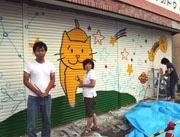 空き店舗のシャッターに猫のイラスト－「軽トラ市」でお披露目