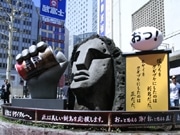 渋谷・モヤイ像に巨大な「腕」出現－缶コーヒー片手に新島観光PR