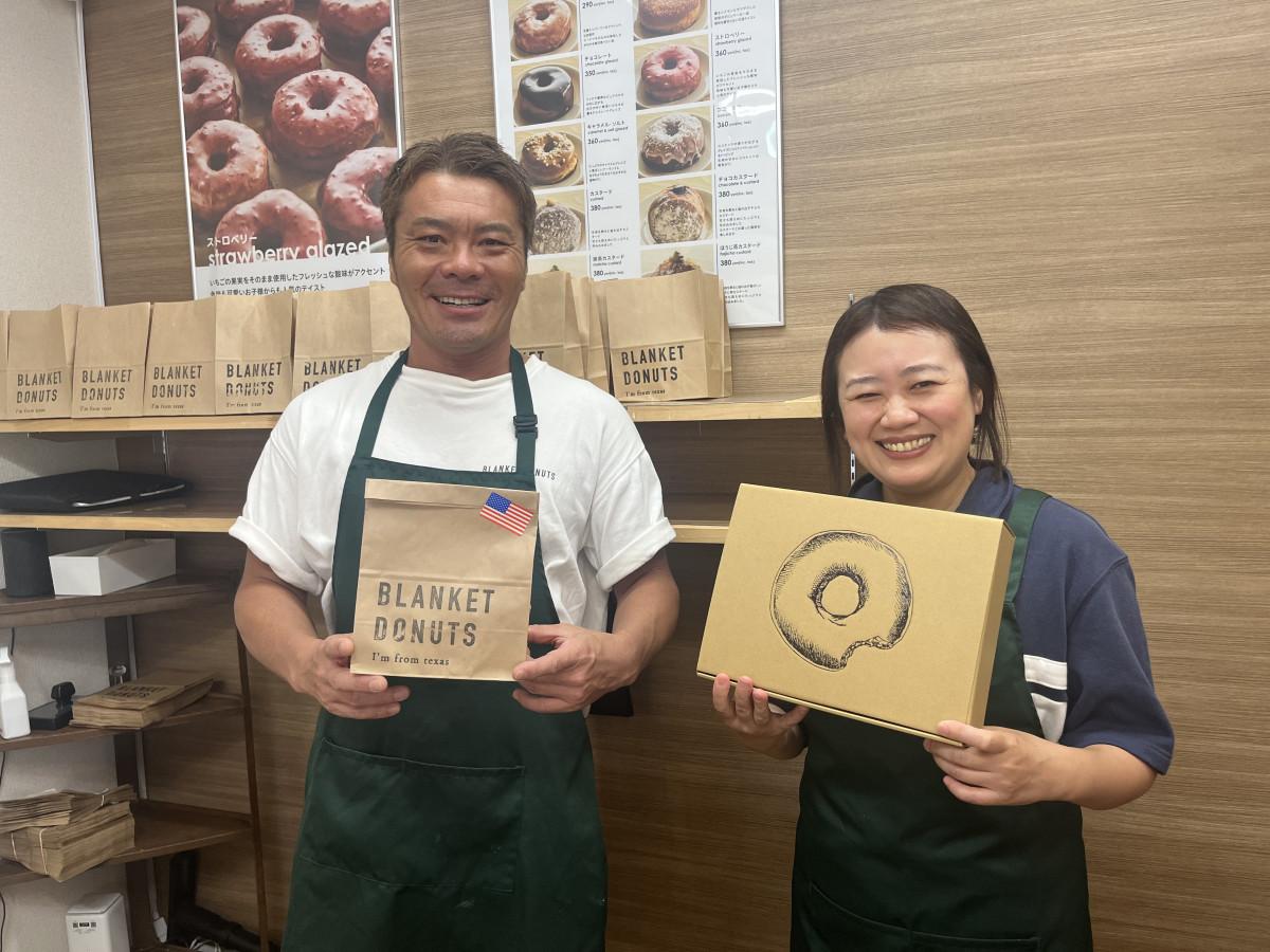 ドーナツの前に立つ店主の宇田川洋平さん（左）とスタッフの木村芙美子さん（右）