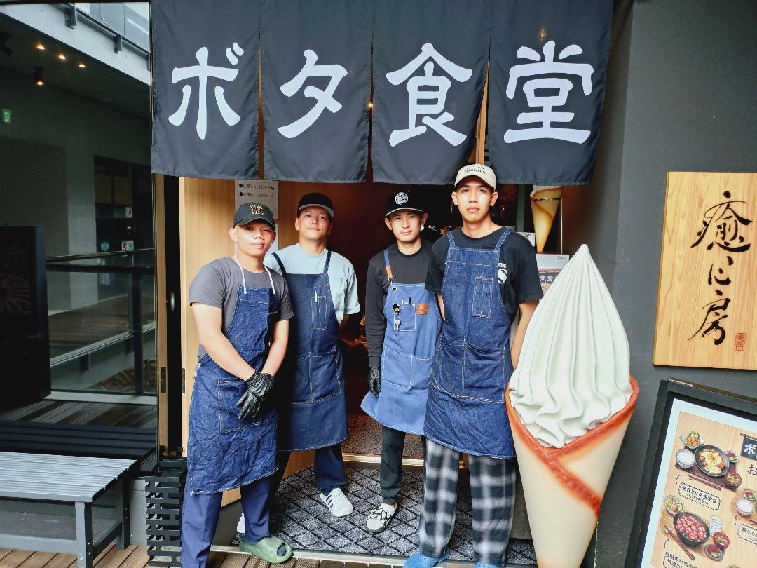 のれんの前に立つスタッフたち＝飯塚にボタ食堂開店（写真提供＝ボタ食堂）