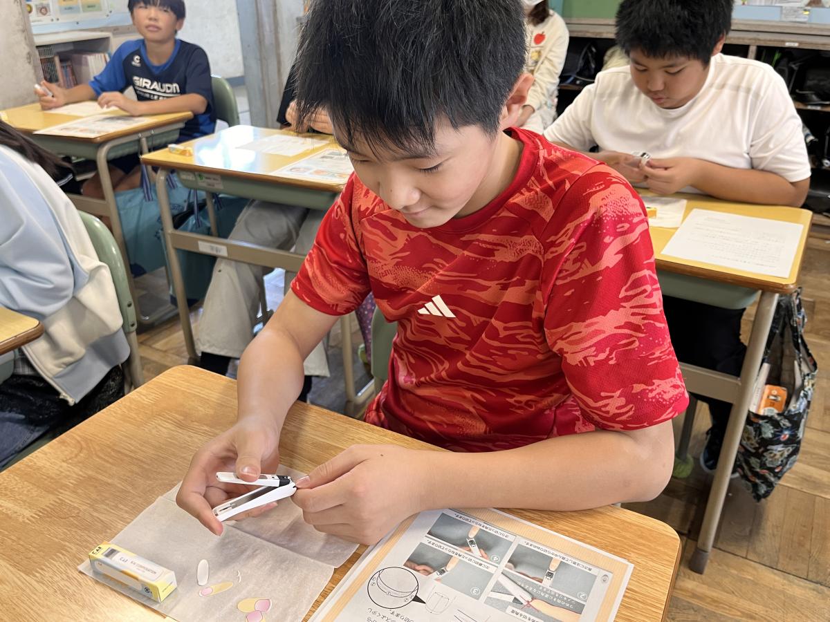 真剣な表情で爪を切る児童