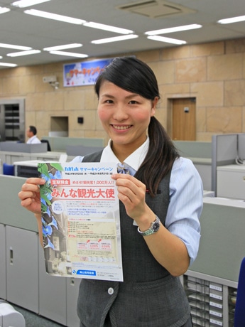 案内パンフレットを手にする受付担当者