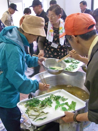 摘みたての山菜を天ぷらにして楽しむ｢春のつどい｣の様子