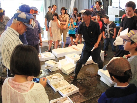 アユの競りを見学する親子参加者たち
