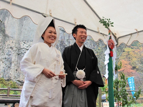 巌立の前で結婚式を挙げた山下賢太郎さん（右）と馬込佳代さん（左）