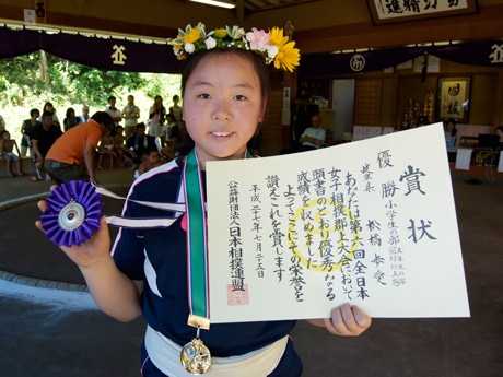 全国優勝の賞状とメダルを手にほほ笑む松橋歩愛さん