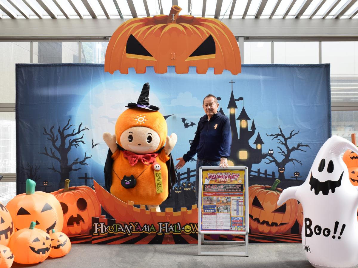 サンロード瓢箪山商店街のキャラクター「ひょうたクン」と瓢箪山中央商店街振興組合理事長の西仲則夫さん