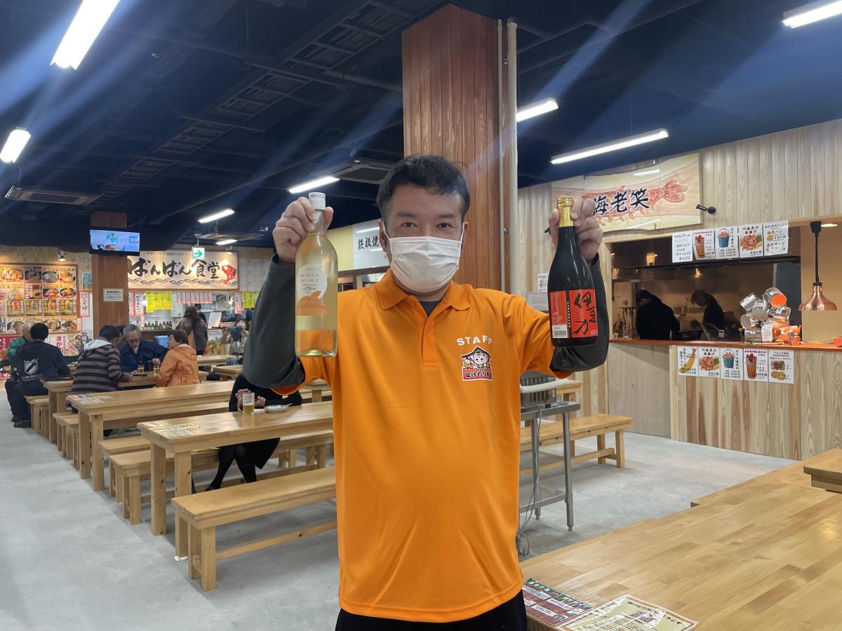 地元のお酒を持つスタッフ