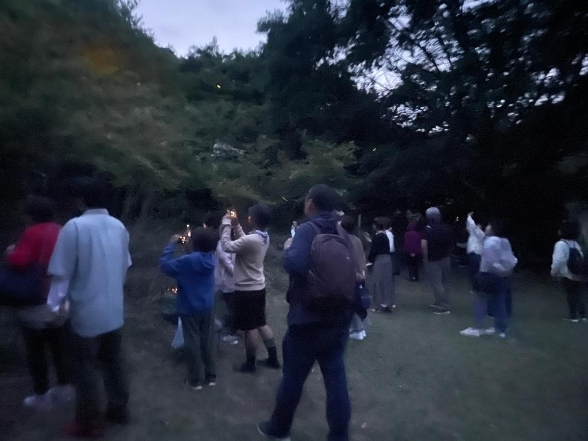 ホタルを囲む観光客