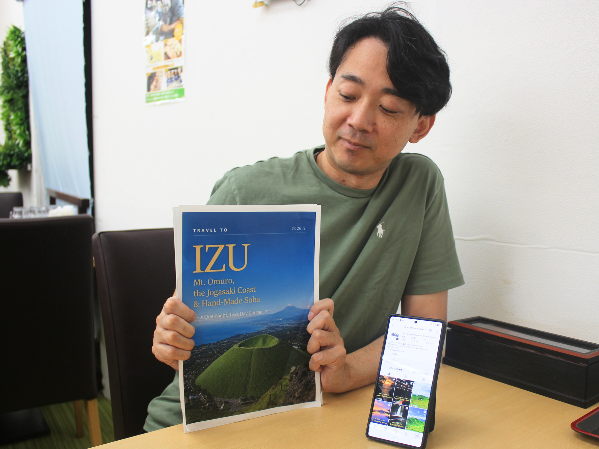 デジタルブック見本を持つ岩崎さん
