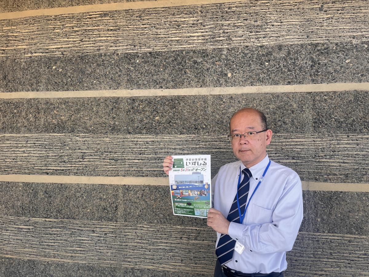 開館を知らせるチラシを手にする伊豆の国歴史館「いずしる」の柴雅房館長