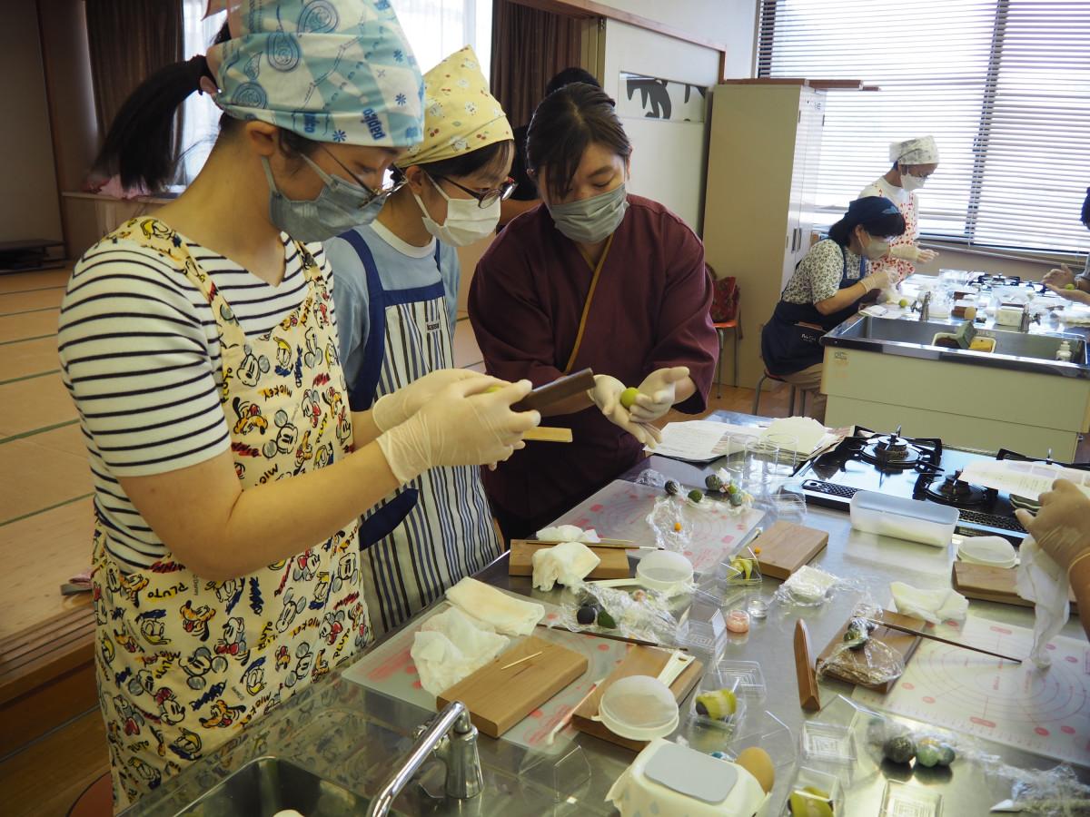 青梅の練り切りを作る参加者に、講師の佐々木典子さん（中央）が手順を説明する