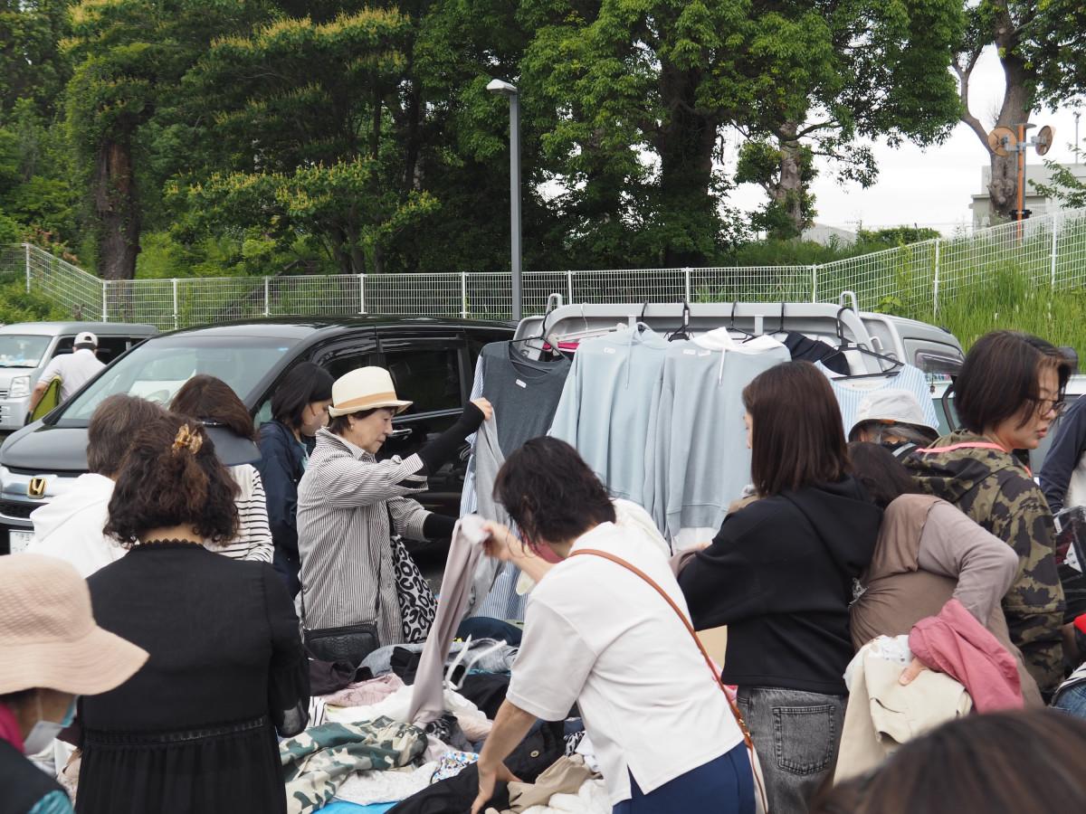 フリーマーケットで衣類を手に取る来場者