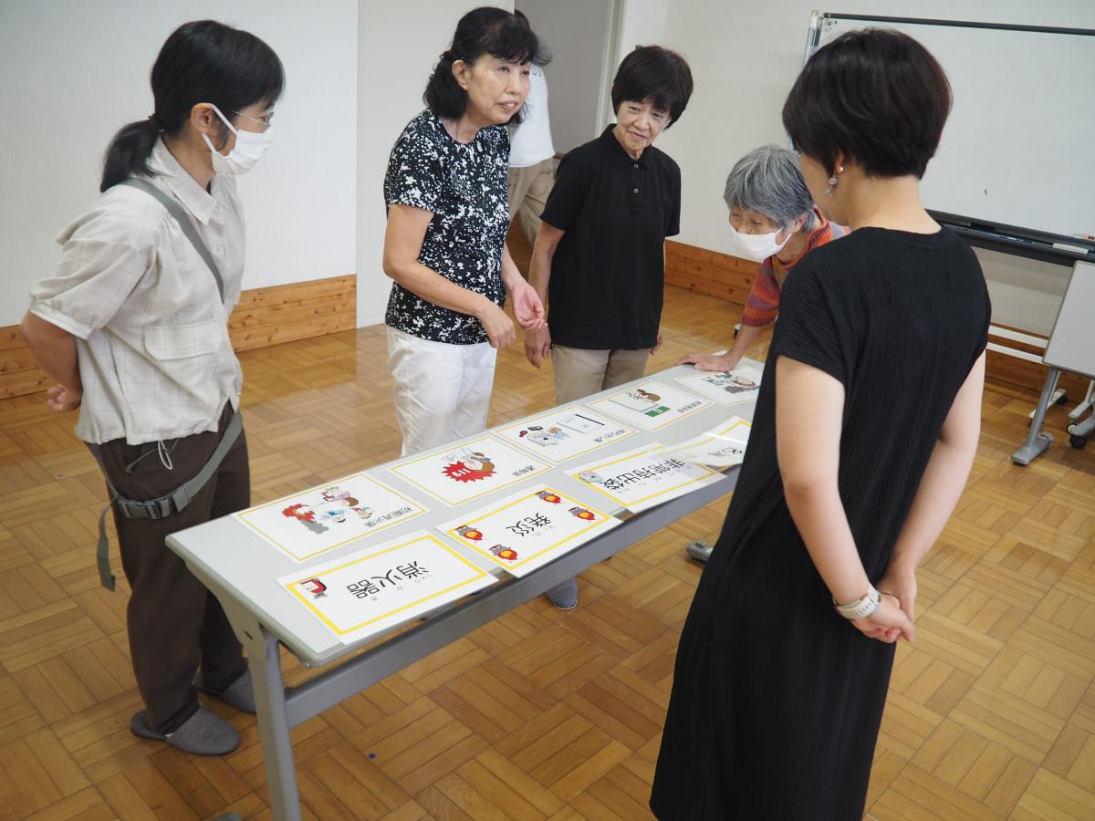 「通報係」「避難誘導係」などのカードを並べ火災発生時の役割分担を確認する参加者