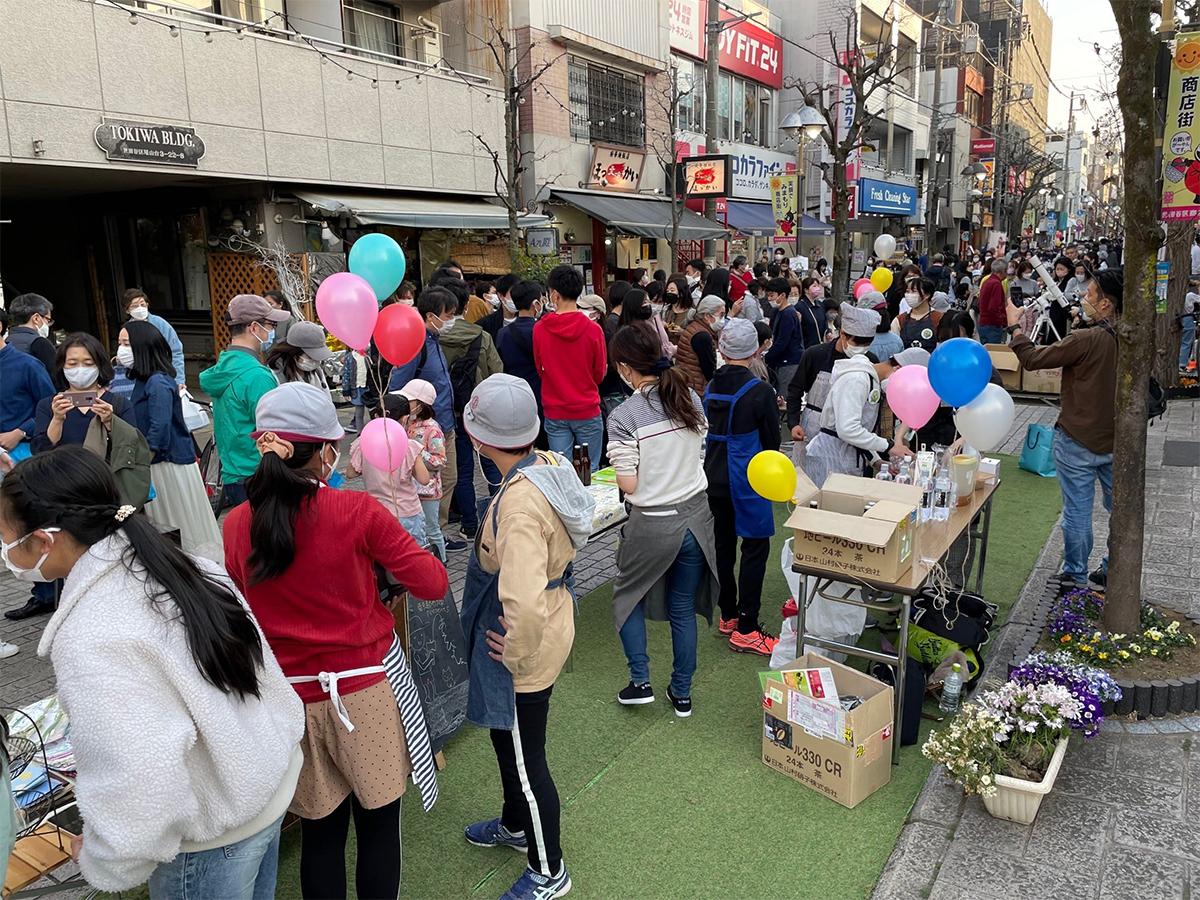 写真は、尾山台商栄会商店街振興組合が今年3月に開催したイベント「6年生が地域とつながる尾山台marche 2022」の様子