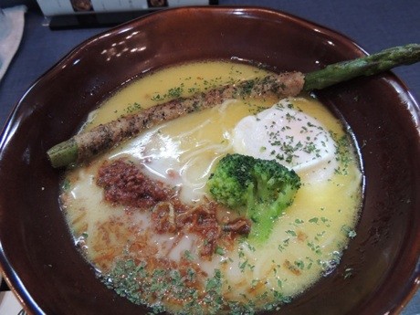 洋風スープの「鶏白湯そば」(840円)。ポーチドエッグ、肉巻きアスパラなどの具が載っている