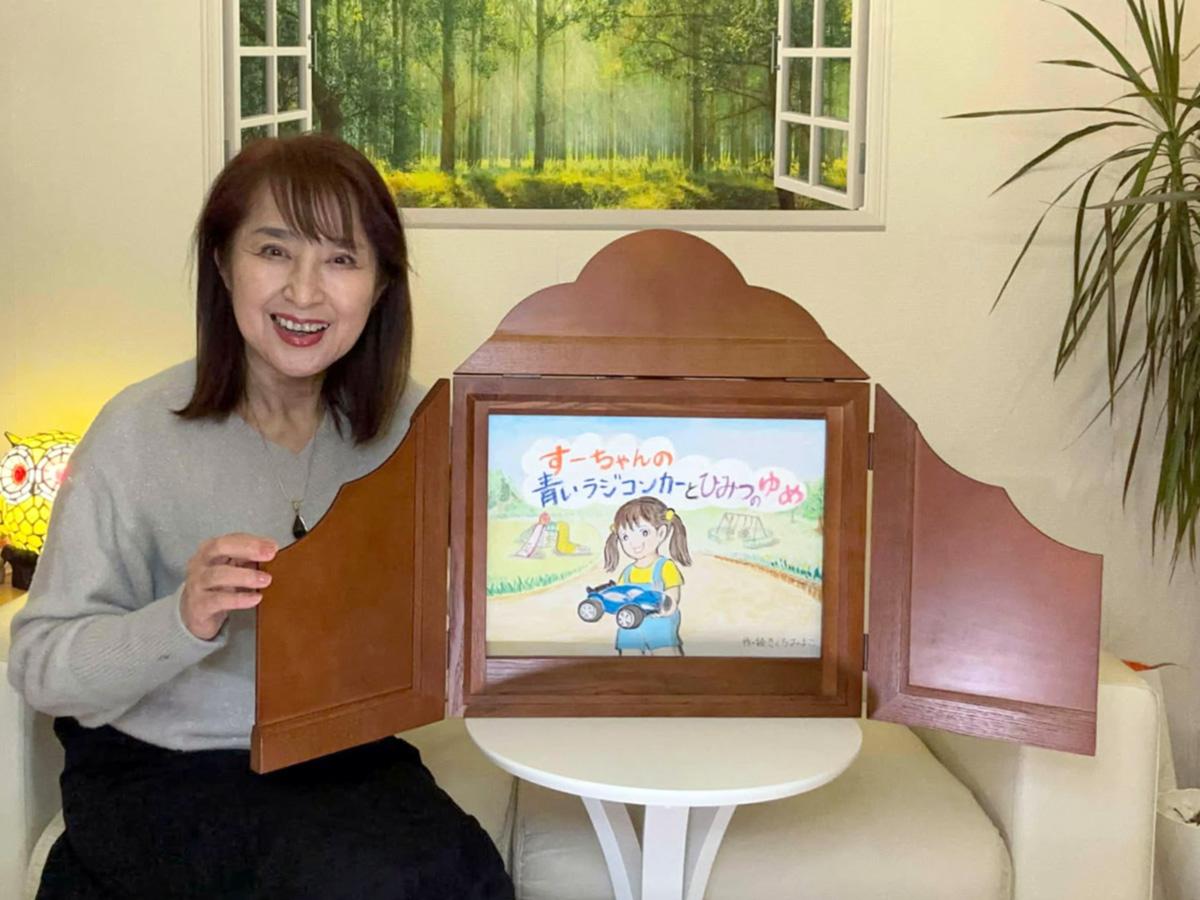紙芝居「すーちゃんの青いラジコンカーとひみつのゆめ」を準備するきくちみよこさん