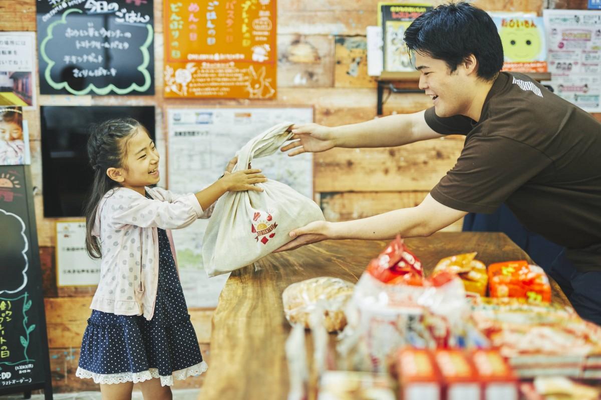 子どもたちに食品を手渡す「おひさまフードパントリー」