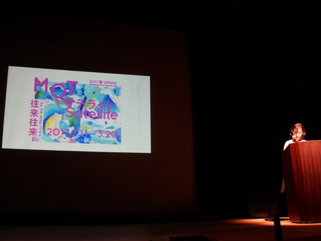メイン画像を投影しプレゼンテーションする学芸員の薮前知子さん。メイン画像は地元の作家「Coci la elle（コシラエル）」ひがしちかさんが手掛けた