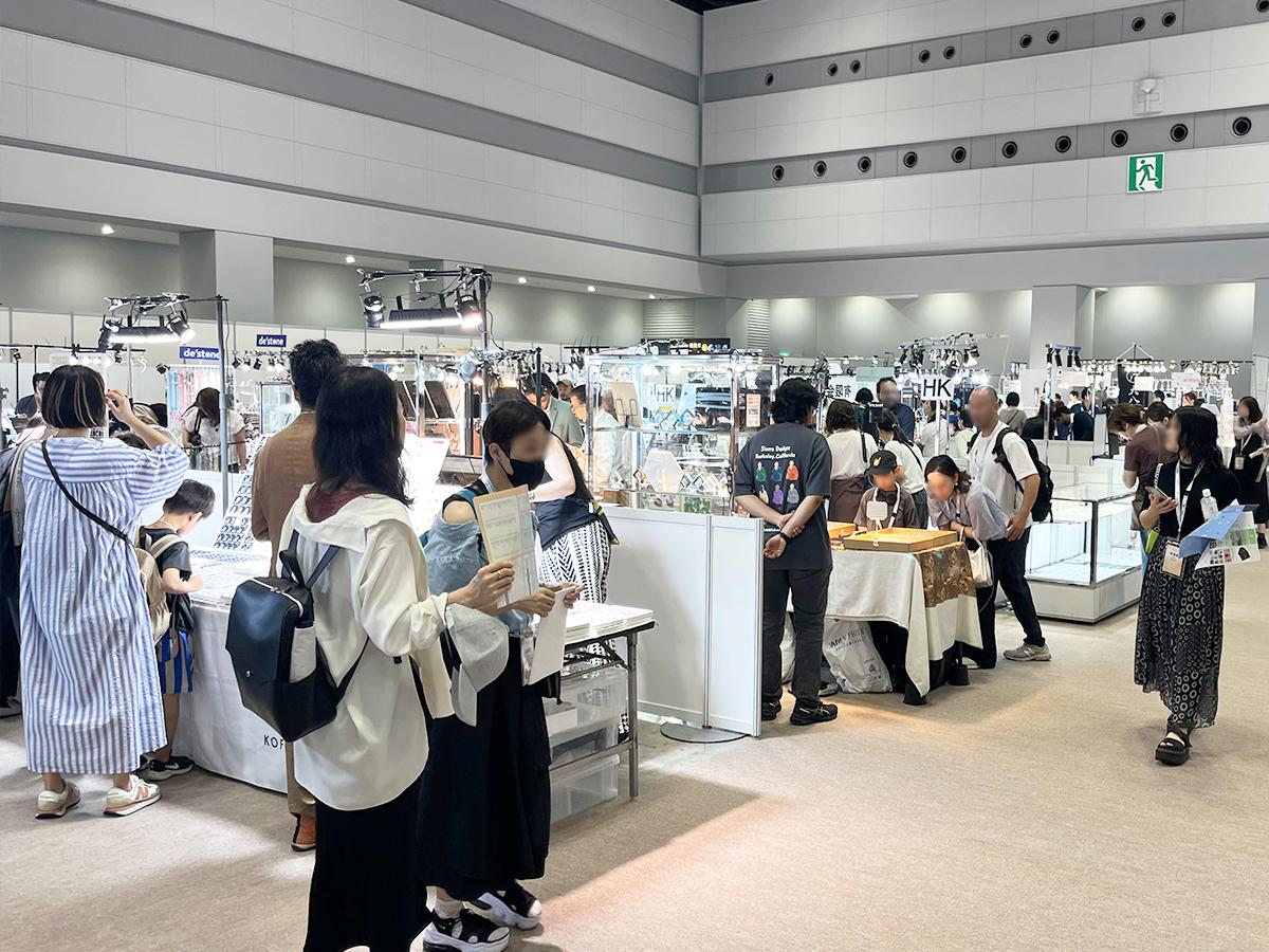 宝石や鉱石などのブースが並ぶ広い会場内をマップを片手に見て回る来場者