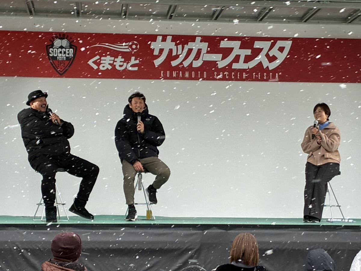 雪が舞う中、ステージでの巻さんのトークショーの様子