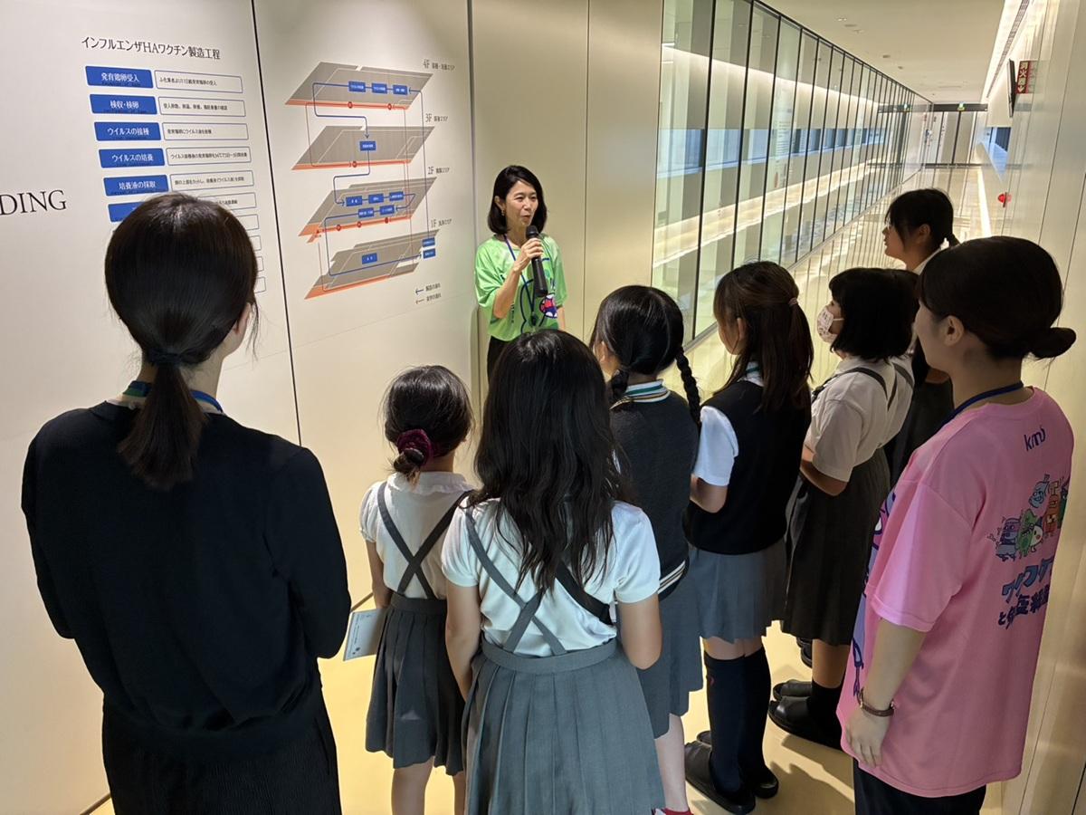 工場見学で職員の話を聞く児童の様子