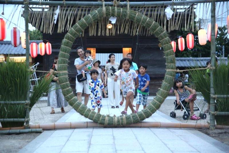 大善寺玉垂宮の境内で茅の輪をくぐる親子連れ（写真提供＝久留米観光コンベンション国際交流協会）