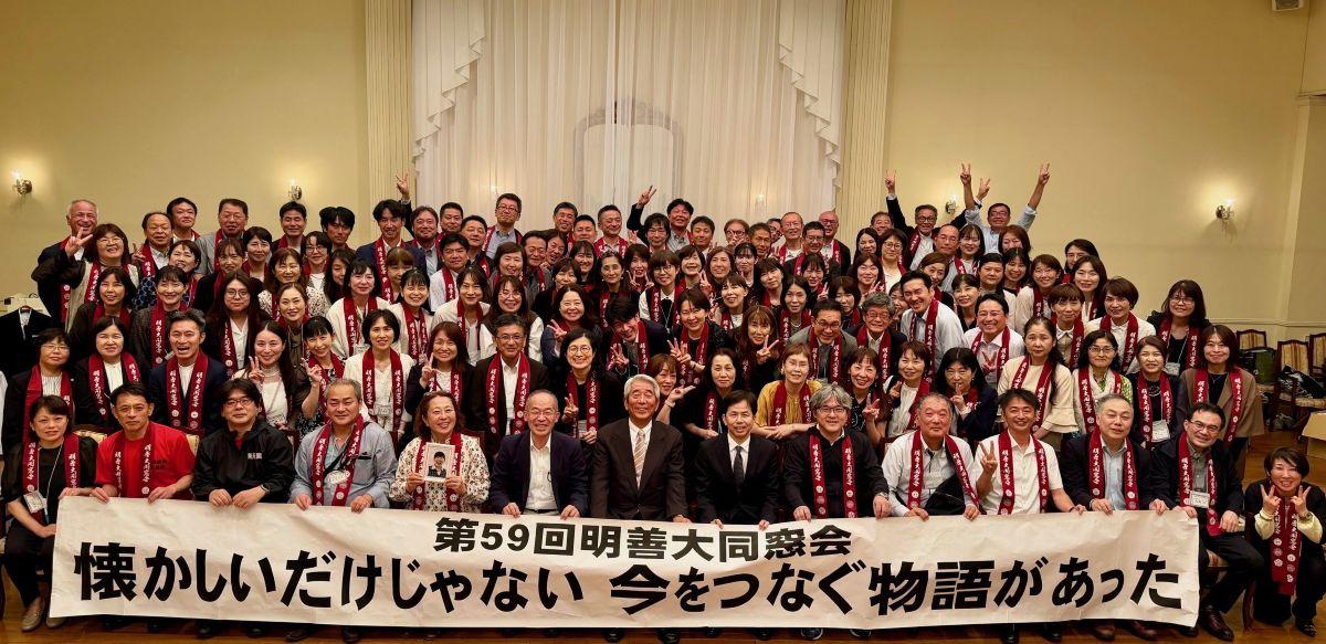 明善大同窓会　会場ステージでの集合写真（写真提供＝明善同窓会　H2会）