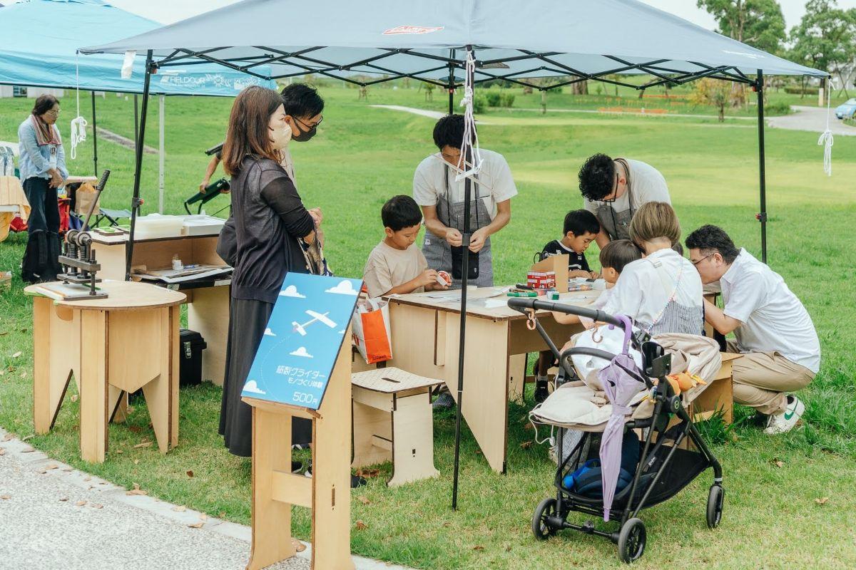 郷土玩具の製作や遊びを体験する「玩具祭（がんぐまつり）」がみやま市で開かれる。屋外の点とで玩具作りを楽しむ参会者（過去実施時）写真提供＝筒井時正玩具花火製造所