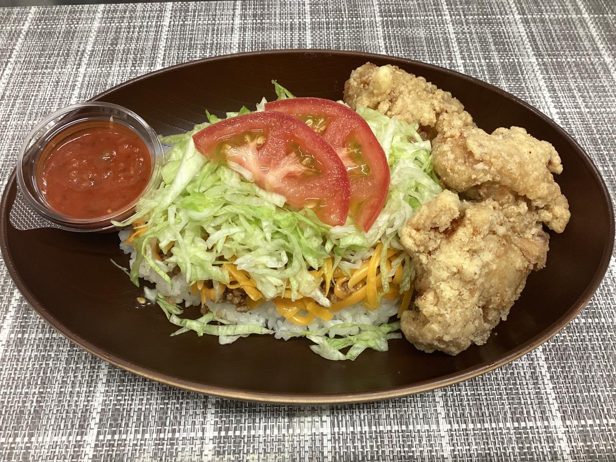 看板メニューの「タコライス チーズ野菜 唐揚げ3個セット」（1,600円）　タコライスの人気に負けない唐揚げ