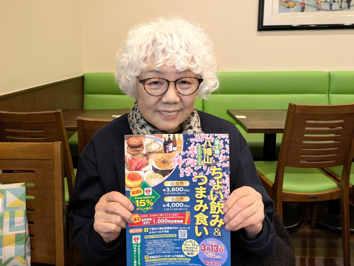 パンフレットを持つ八幡山商福会商店街振興組合の小塚千枝子理事長