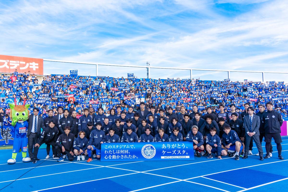 バックスタンドのサポーターと、百年構想リーグを戦い抜いた水戸ホーリーホックの選手、監督、コーチ、スタッフ