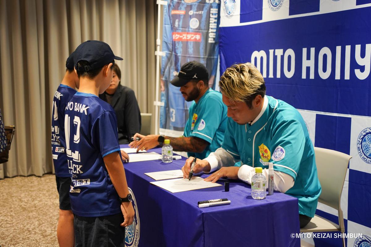 サインするパトリッキ選手（左）と松原修平選手