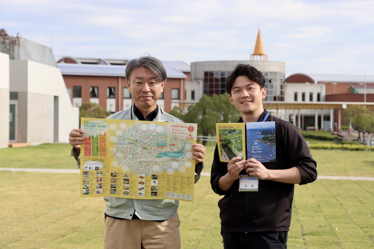 （左から）サイクリングガイドを手に参加を呼びかける、茨城町商工観光課の鬼沢稔明さん、岩瀬寛幸さん