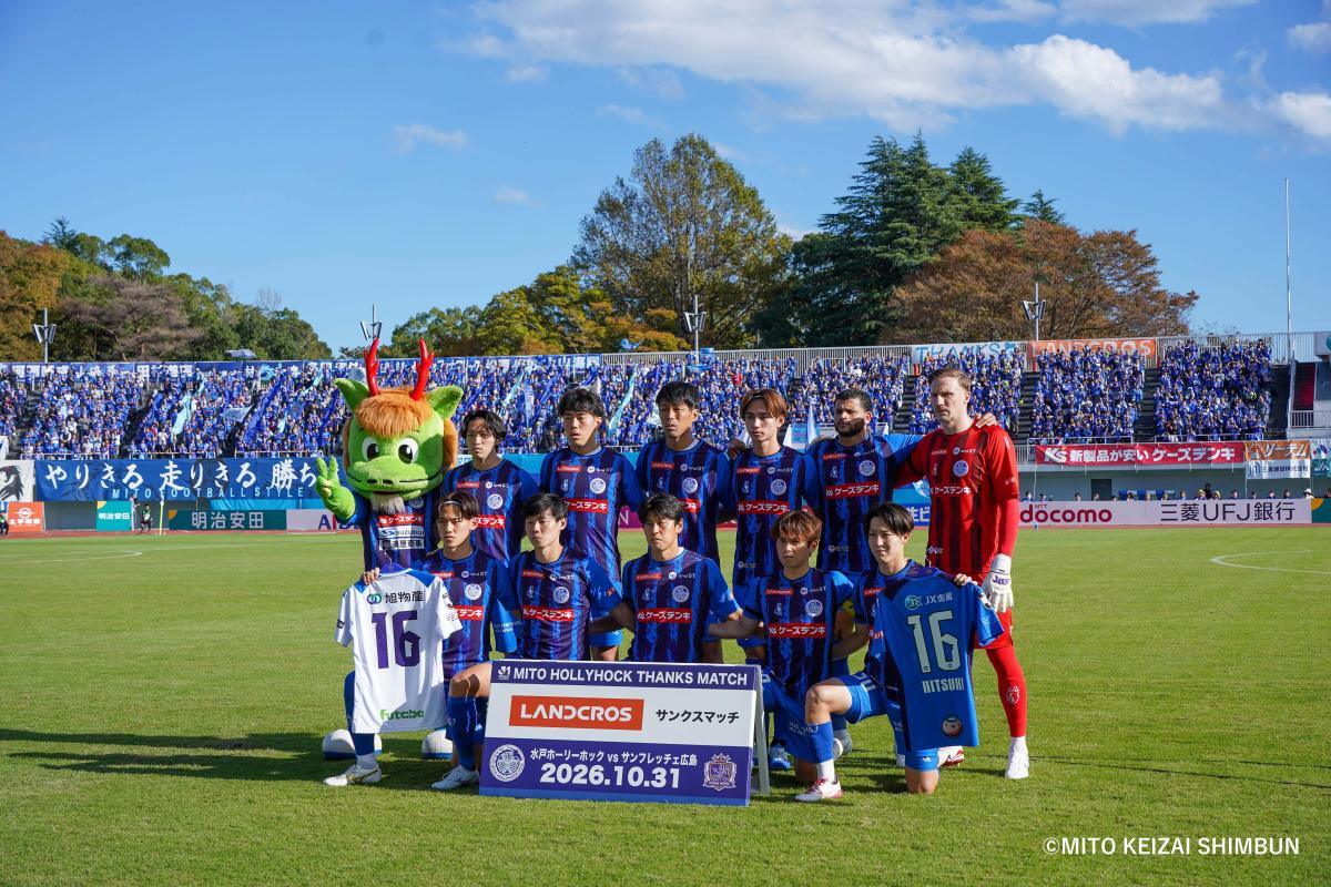 冨田選手のユニホームを手に集合写真を撮影するスタメン