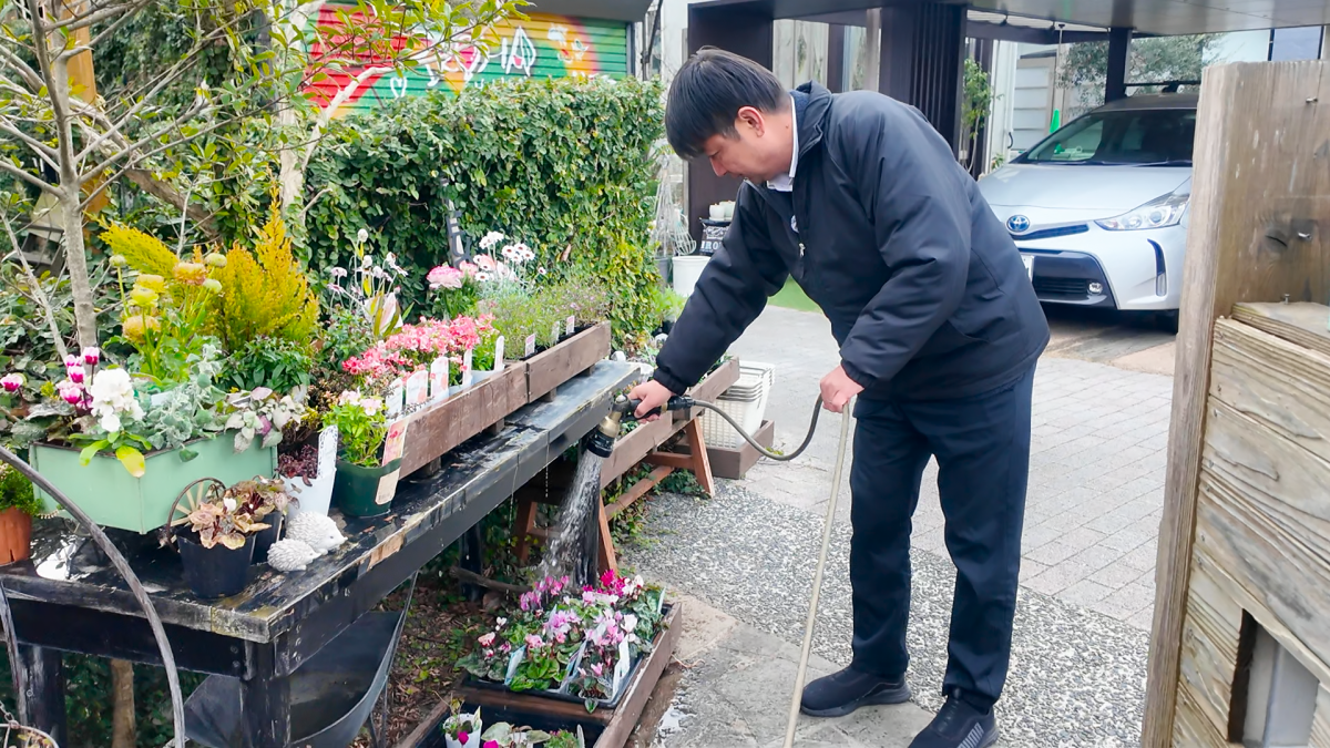 花の水やりをする枇杷光二さん