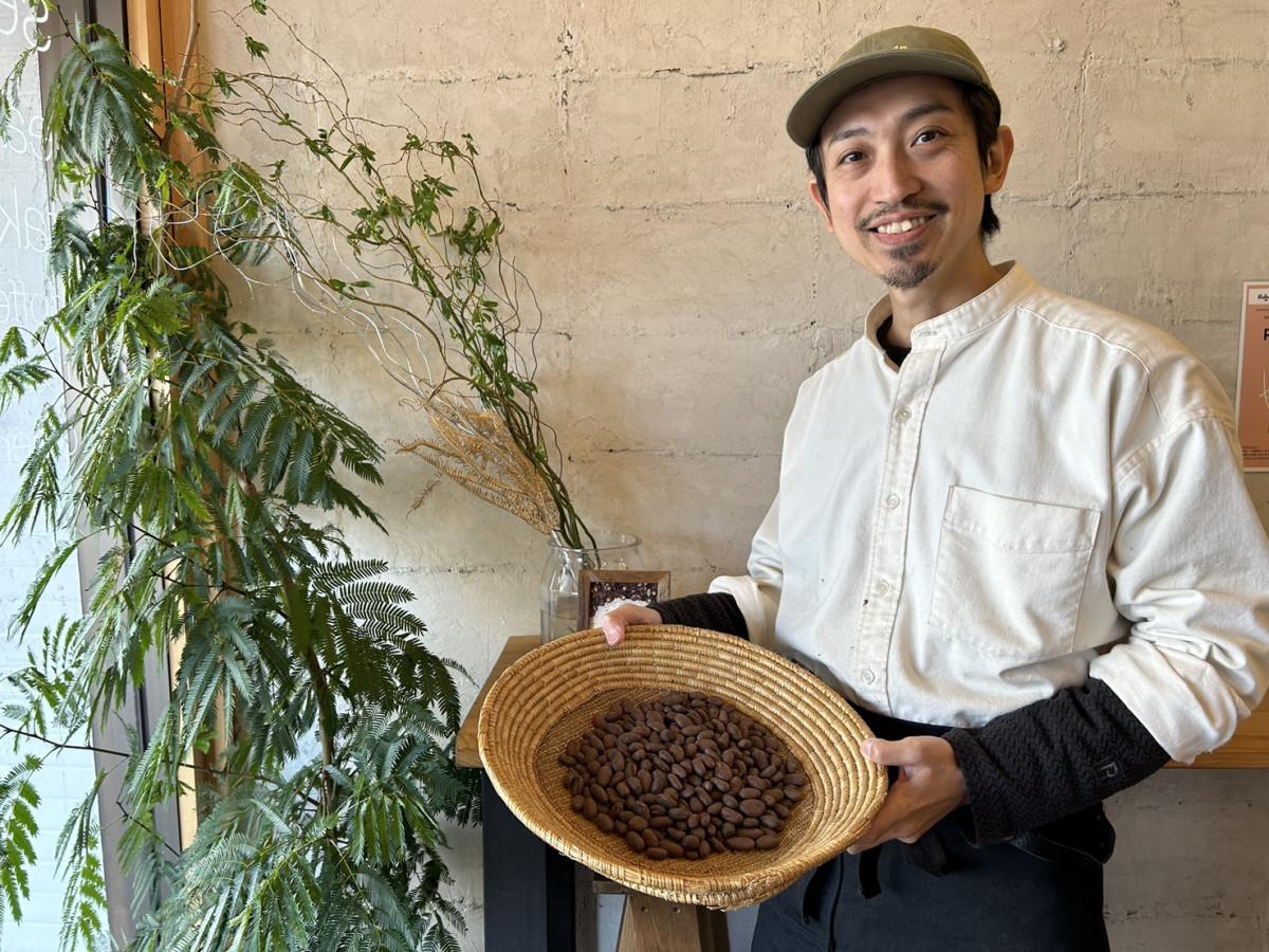 カカオ豆を持つカカオウム店主の大山さん