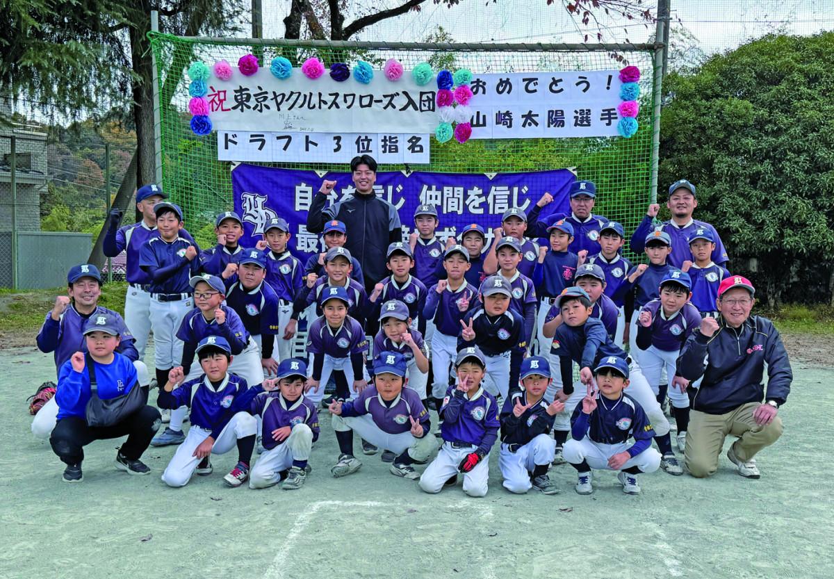 大歓声で迎えられた山崎投手（後列中央）は選手たちと記念撮影