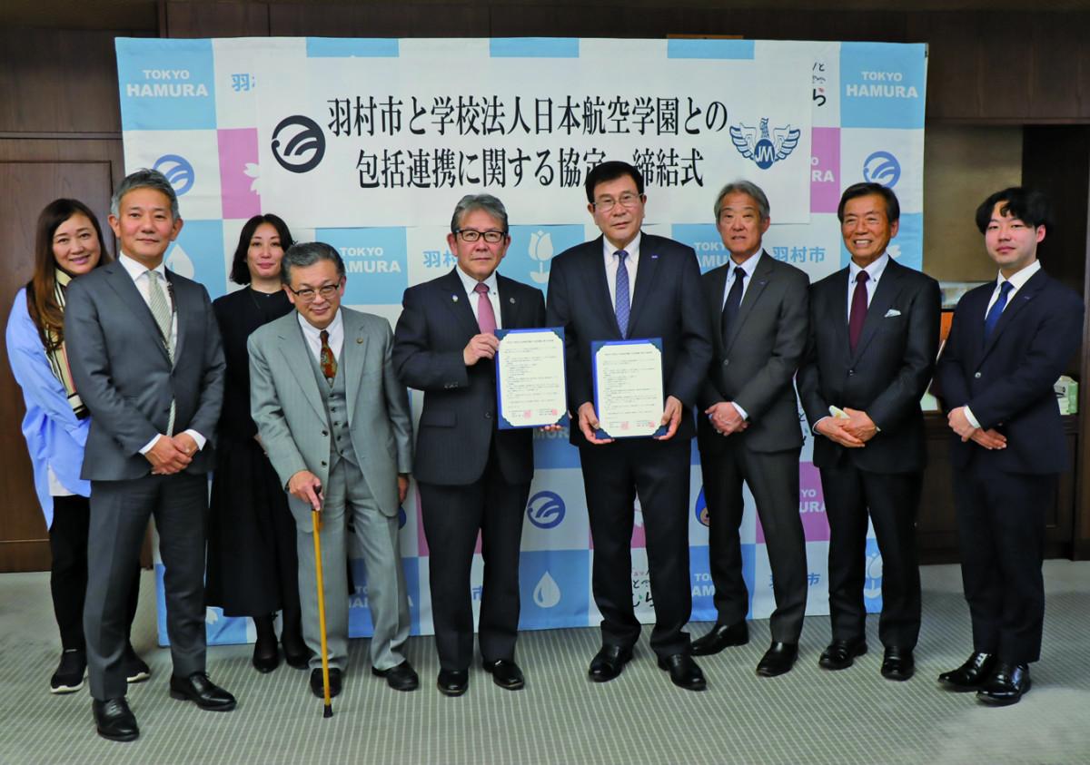 協定書を持つ橋本市長（中央左）と梅田理事長（同右）