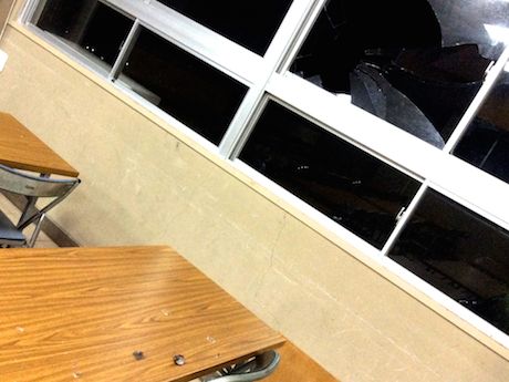 割れた窓ガラスと飛び散る羽毛