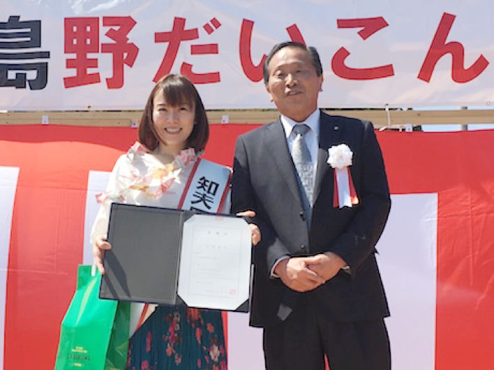 半崎美子さん(左)と平木伴佳知夫村長(右)