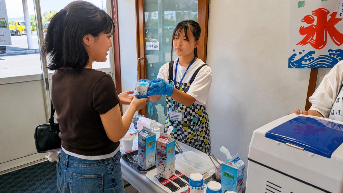 教習生にかき氷を手渡す中学生