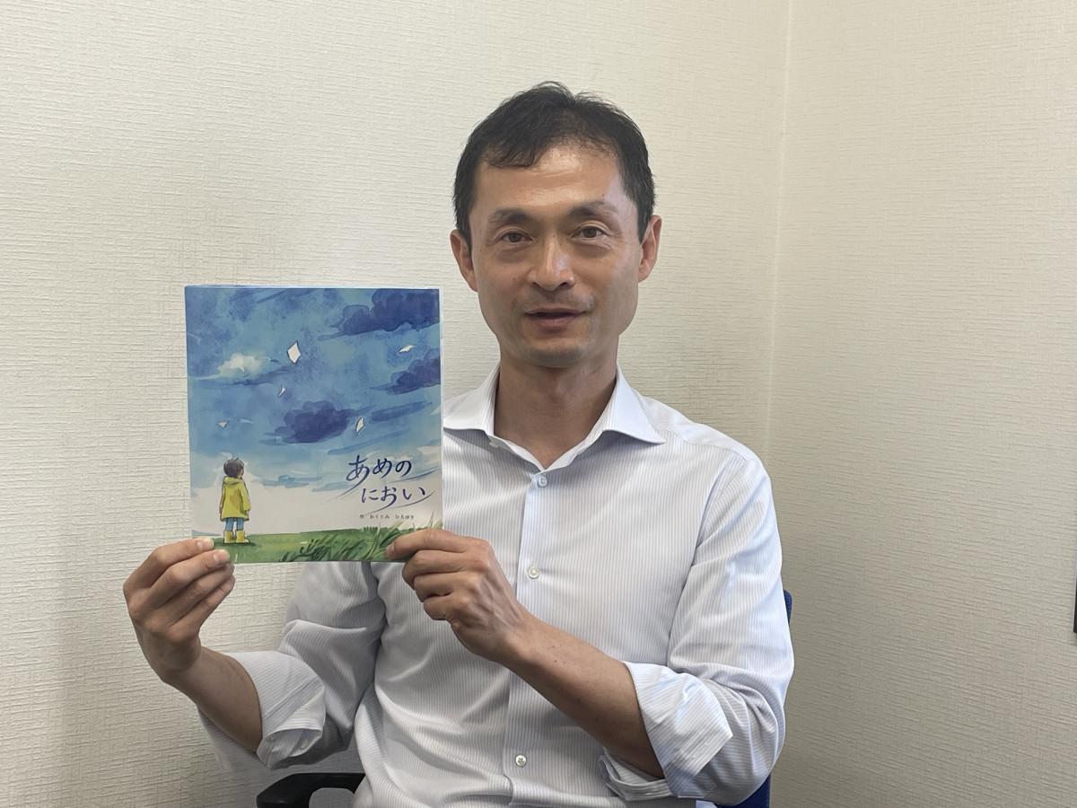 絵本を持つ奥富さん
