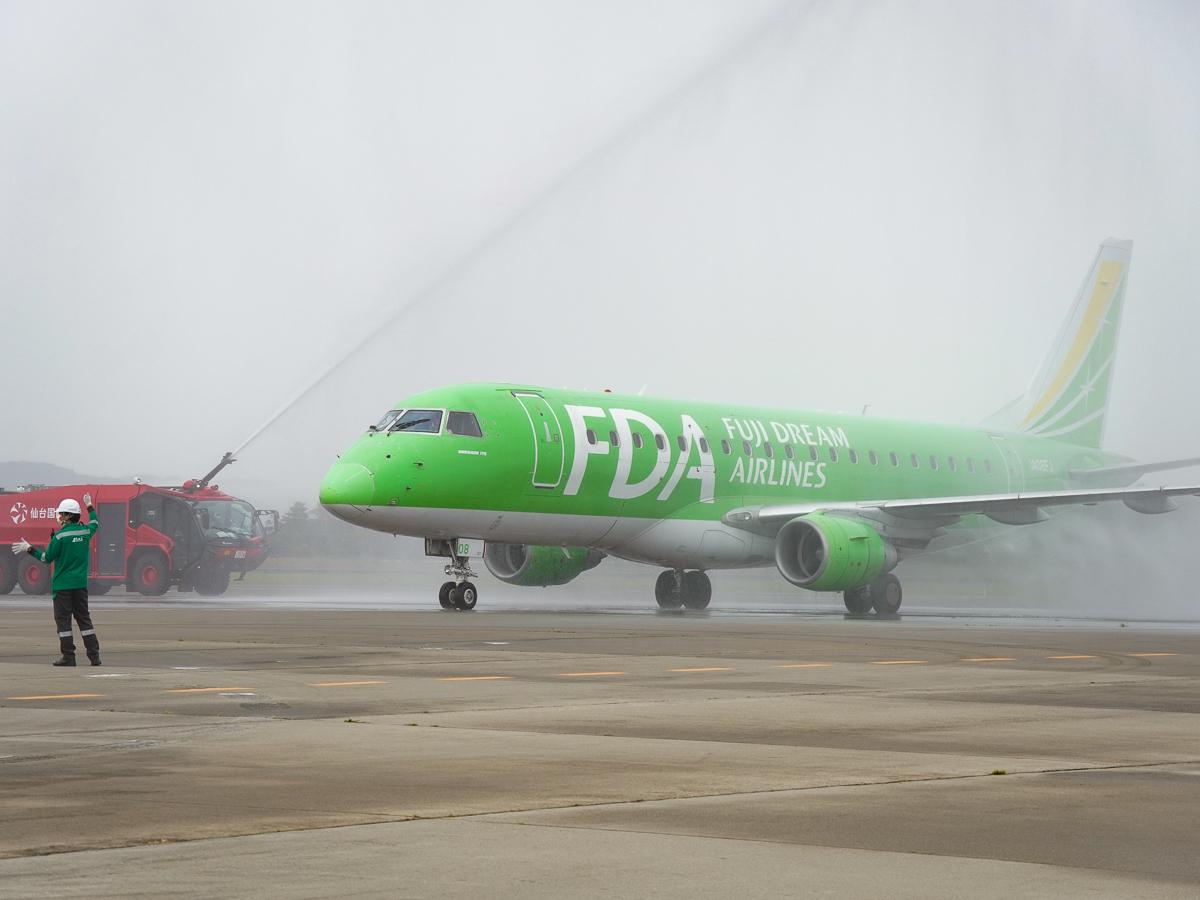 放水アーチに迎えられ仙台空港に到着した島根からの初便（25日12時ごろ撮影）