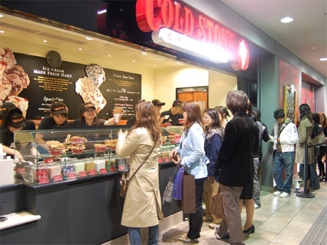 23日夕方、店の前は行列客でにぎわう。アイスを混ぜながらスタッフがオリジナルソングを歌う場面も
