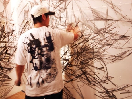 写真＝展覧会に向けて「GALLERY SCENE」内の壁面にペイント中の松岡亮さん