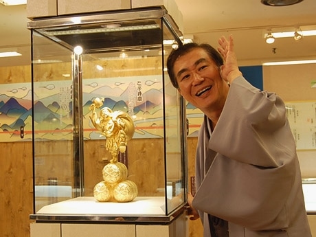 GINZA TANAKAが製作した純金製「踊る大黒天」の前で「いらっしゃーい」を披露した桂三枝さん。純金製「踊る大黒天」（8,000万円）は希望があれば販売も行うという