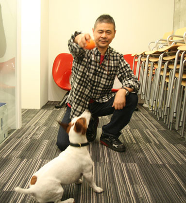 愛犬ブイヨン（写真下）と遊ぶ糸井さん（写真上）。当日はそろって来店し、初の「名刺」を披露する