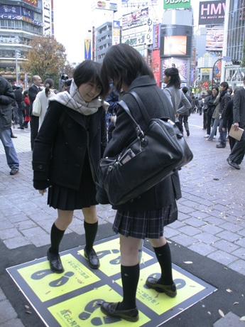 渋谷ハチ公前広場の舗装タイルに埋め込まれた「発電床」に立つ女子学生ら