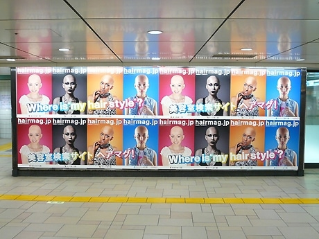 表参道駅構内に掲出されたポスター。スキンヘッドのビジュアルで美容室検察サイトをPR